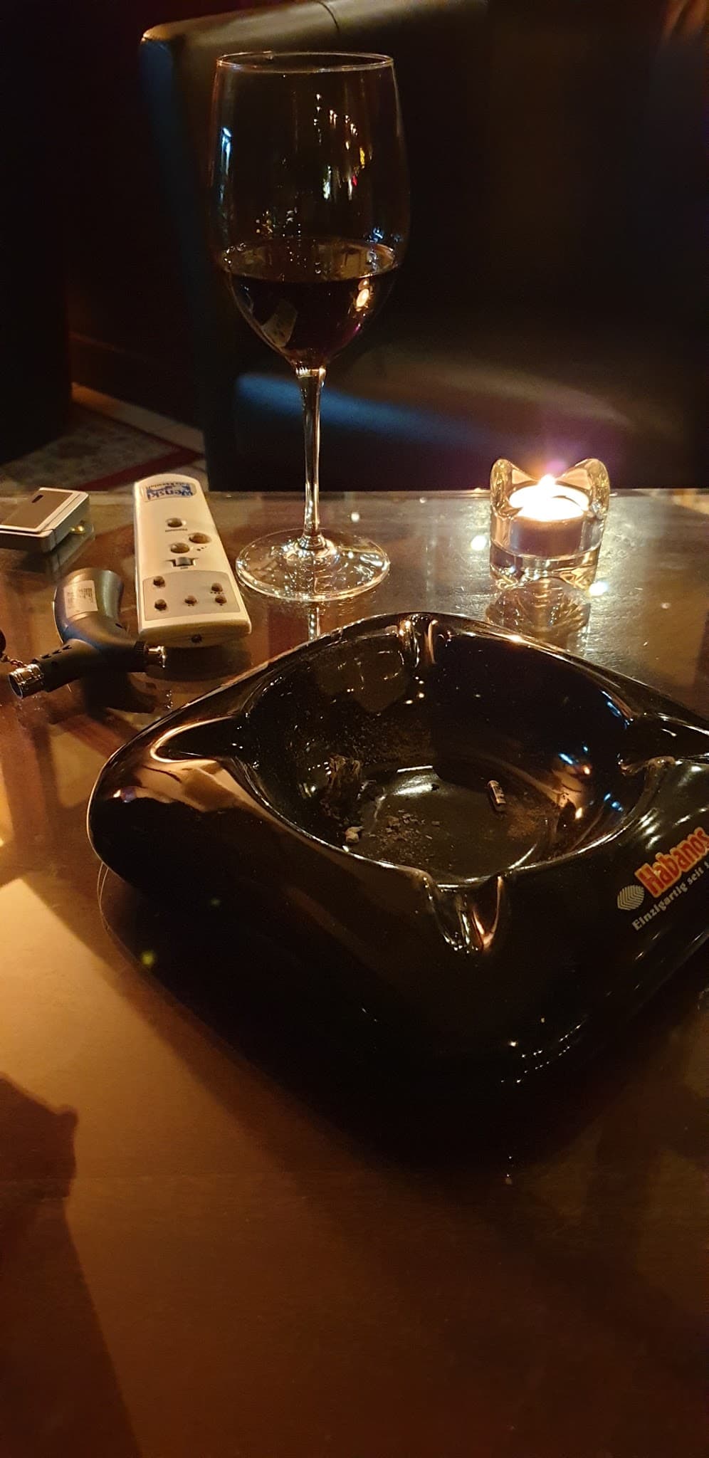 Zigarrenasche mit Wein und Kerze