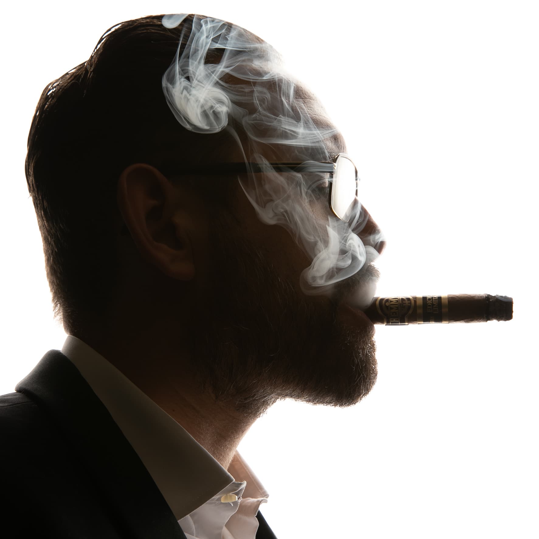 Mann mit Zigarre und Brille im Profil