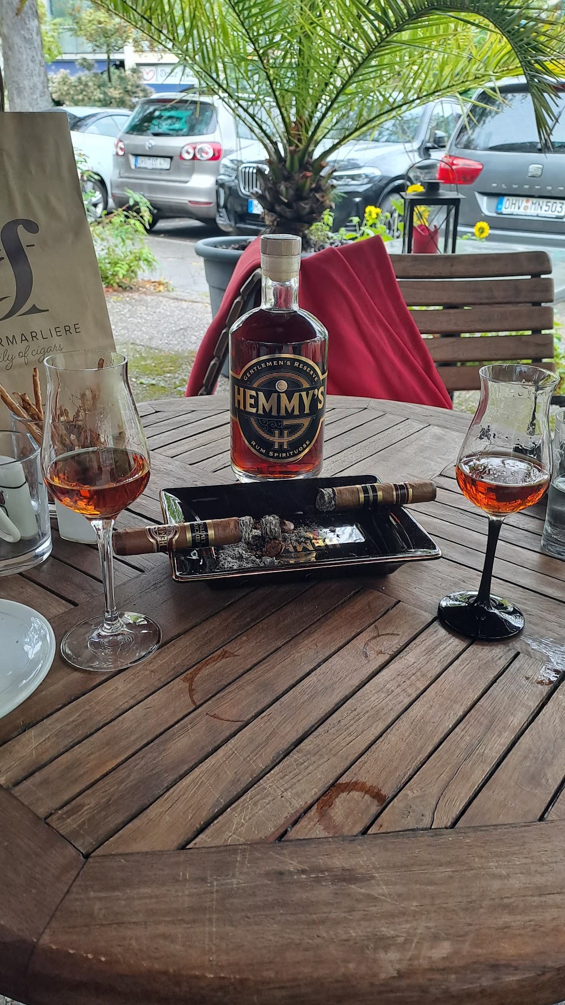 Hemmy's Rum mit Gläsern und Zigarre im Außenbereich